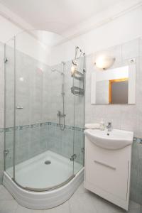 y baño con ducha y lavamanos. en Lux Apartmanok, en Hajdúszoboszló