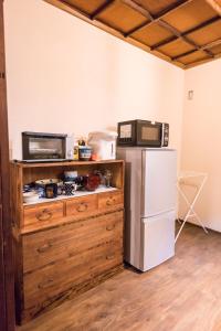 uma cozinha com um micro-ondas e um frigorífico em DOT HOUSE NAGANO Traditional Japanese house - Vacation STAY 82102 em Nagano