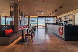a restaurant with a bar with tables and chairs at BALUARTE POUSADA in Torres