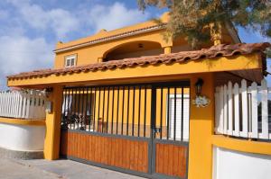 a yellow house with a gate and a fence at La Fenice in Lampedusa