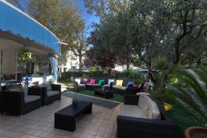 a group of couches and tables on a patio at Hotel Lido Europa in Riccione