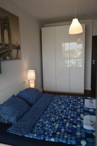 sypialnia z łóżkiem z niebieską pościelą i lampką w obiekcie Apartament Nadwarciański w Poznaniu