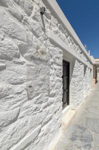 un edificio di mattoni bianchi con un cartello sopra di Diadema Apartments in the Town a Naxos Chora