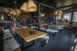 a restaurant with tables and chairs in a room at Kau Lodge in Puerto Natales