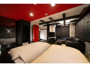 a bedroom with two beds and a living room at Royal Hotel Uohachi Bettei - Vacation STAY 81418 in Ogaki