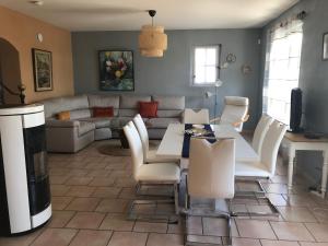 una sala de estar con un sofá, una mesa y sillas en La Bastide de l'Olivier, en Flassan