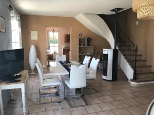 Una sala de estar con una mesa y sillas blancas. en La Bastide de l'Olivier, en Flassan