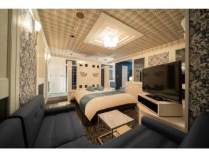 大垣市にあるRoyal Hotel Uohachi Bettei - Vacation STAY 81417のベッドルーム(ベッド1台、テレビ、ソファ付)