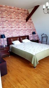 a bedroom with a bed and a brick wall at Cztery Pliszki in Gródek Nad Dunajcem