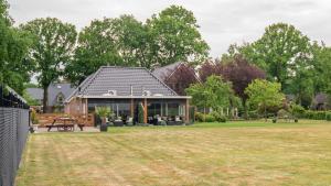 una casa con un gran patio delante de ella en B&B Hertenhoef, Fluitenberg (Hoogeveen), en Fluitenberg