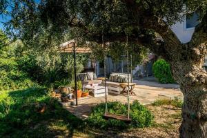 a swing hanging from a tree in a yard at Alexandra Apartments in Stoupa