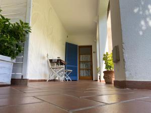 a porch with a chair and a blue door at Valle dei Mulini B&B in Marciana