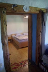 Chalupa Na Košáře في Valašská Senice: غرفة نوم مع سرير مع ساعة على الحائط