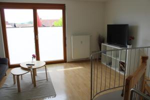 a living room with a table and a tv at Winzerhof Senn in Vogtsburg