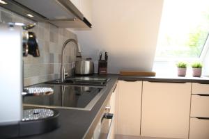 Ferienwohnung Strom ahoi - premium - modern - inkl Stellplatz - 200m zum Alten Strom - Wasserblick في فارنمونده: مطبخ مع حوض وموقد الفرن العلوي