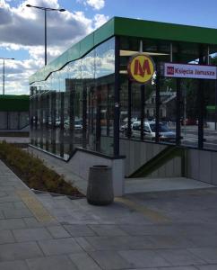 un bâtiment de type mcdonalds avec un panneau devant lui dans l'établissement Apartment Mona Warsaw przy stacji metra, à Varsovie