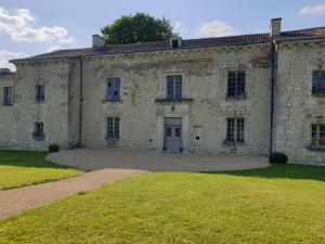 L'Olivier في Monts-sur-Guesnes: مبنى حجري قديم وامامه ساحة عشب