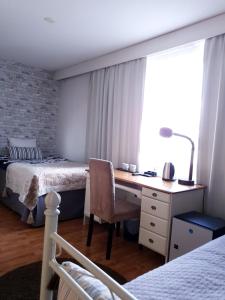 1 dormitorio con escritorio y 1 cama y 1 cama y 1 escritorio en Majoitus Hermanni en Teuva