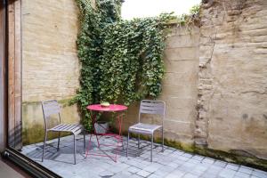 a red table and two chairs and a table and a wall at Well-situated and Comfortable Home in Ghent