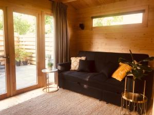 a black couch in a room with a sliding glass door at LODGE 5 Zandvoort in Zandvoort