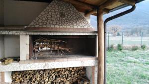 un forno all'aperto con un mucchio di legna da ardere di Chalet Del Pozzo a Luco dei Marsi