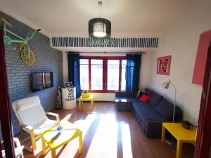 sala de estar con sofá azul y TV en GINGER apartment, en Alicante