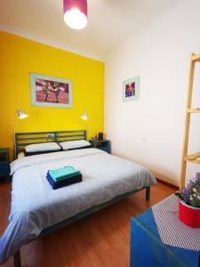 1 dormitorio con cama y pared amarilla en GINGER apartment, en Alicante