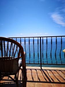 a chair sitting on a balcony looking at the ocean at Villa Eros Apartments in Struga