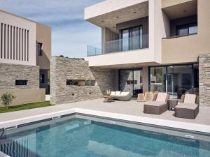 a house with a swimming pool in front of it at Aguacate Agave in Tsilivi