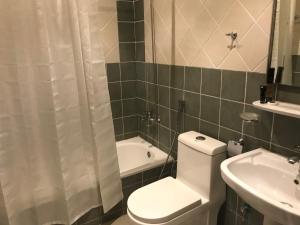 a bathroom with a toilet and a tub and a sink at Najran Hotel in Najran