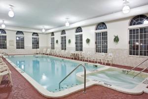 a large pool in a hotel with tables and chairs at Holiday Inn Express Birch Run-Frankenmuth Area by IHG in Birch Run