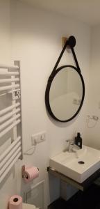 
a bathroom with a toilet, sink and mirror at La Villa des Remparts in Lisieux

