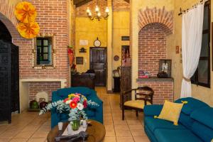 a living room with two blue couches and a fireplace at Hotel Las Marias in Antigua Guatemala