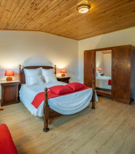 a bedroom with a large bed and a mirror at Casa dos Castanheiros in Vila Verde