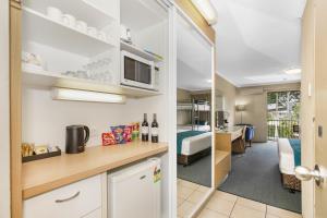 a kitchen with a counter and a living room at Best Western Airport 85 Motel in Brisbane