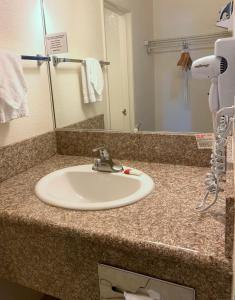 a bathroom counter with a sink and a mirror at Super 8 by Wyndham Las Vegas North Strip/Fremont St. Area in Las Vegas