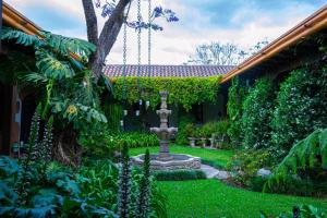 a garden with a fountain in the middle of a yard at Hotel Las Marias in Antigua Guatemala
