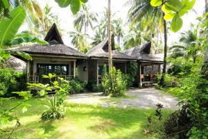 
a large garden with trees and palm trees at Surfing Carabao Beach Houses in General Luna
