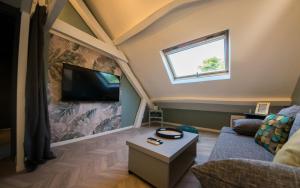 a living room with a flat screen tv on a wall at Gîte Mise au Vert in Bruyères-et-Montbérault