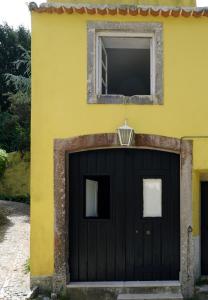 ein gelbes Haus mit einer schwarzen Garage mit einem Fenster in der Unterkunft Charm Inn Sintra in Sintra