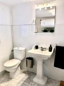 a white bathroom with a toilet and a sink at Casa Nadal in Concud