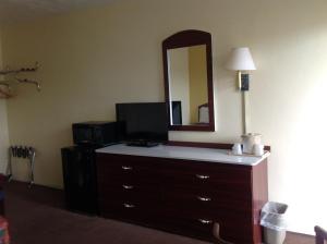 a room with a large mirror and a dresser at Economy Inn Okeechobee in Okeechobee