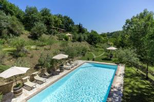 Una vista aérea de una piscina con sillas y sombrillas. en Bright apartment in Montepulciano with shared pool - 45 m², en Montepulciano