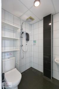 een badkamer met een douche, een toilet en een wastafel bij Rumahku Express, Georgetown, Penang in George Town