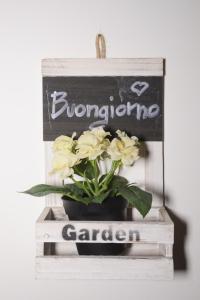a plant in a pot on a shelf with a sign at De Rossi Holiday 'Rooms&Apartment' in Bari