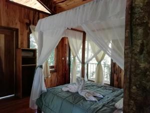 um quarto com uma cama com dois cisnes em Monteverde Romantic Cottage em Monteverde