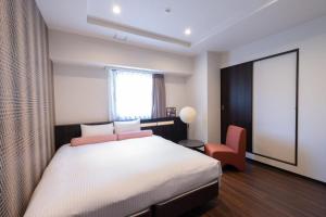 大阪市にある日本橋 Luxe Hotelのベッドルーム1室(ベッド1台、椅子、窓付)