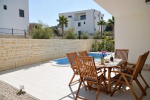 a patio with a table and chairs next to a pool at Apartment Nata - free parking in Murter