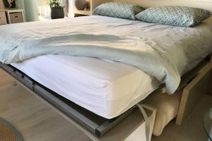 a bed with white sheets and pillows on it at ANTINEA in Cassis