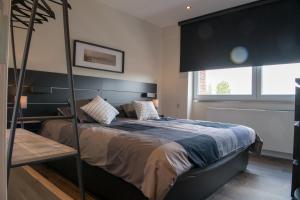 een slaapkamer met een groot bed met een zwart hoofdeinde bij Cocoon in East-Brussels in Wezembeek-Oppem